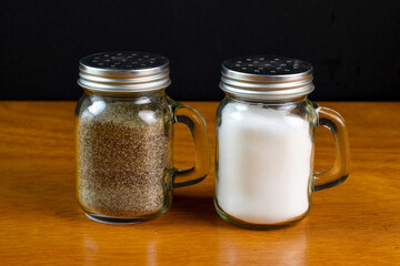 salt and  pepper shakers against a black ground