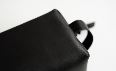 Details of man's black leather personal cosmetic bag or pouch for toiletry accessory. Style, retro, fashion, vintage and elegance.