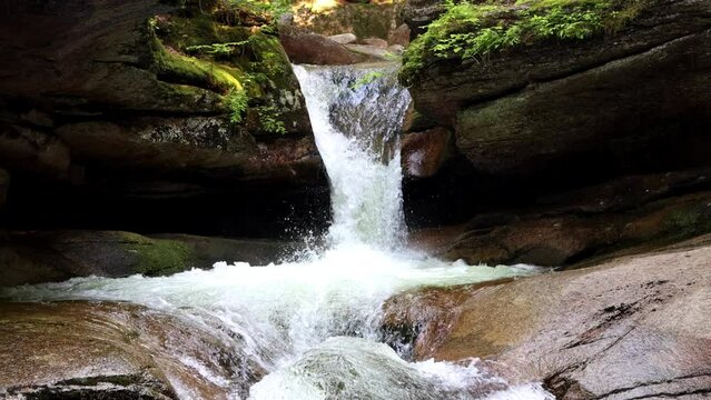 Preciosa cascada de agua entre las rocas de ruta de senderismo en bosque natural