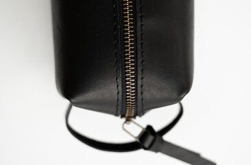 Details of man's black leather personal cosmetic bag or pouch for toiletry accessory. Style, retro, fashion, vintage and elegance.