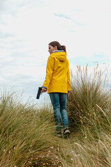 Woman wearing a yellow coat and carrying a pistol, book cover concept.