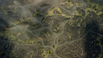 The texture of the surface of the earth near the volcano, black lava and winding paths for hiking....