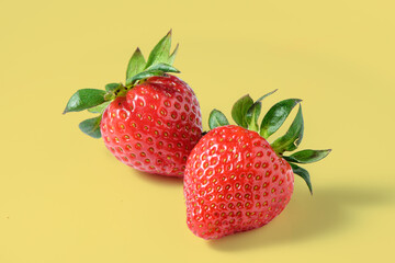 fresh appetizing strawberries on a yellow background, studio shooting