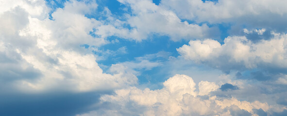 White curly clouds in the blue sky in sunny weather