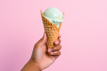 Close up shot of hand holding ice cream against bright background