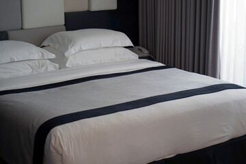 Empty bed in a hotel bedroom with soft cushions. Tourism and vacation concept