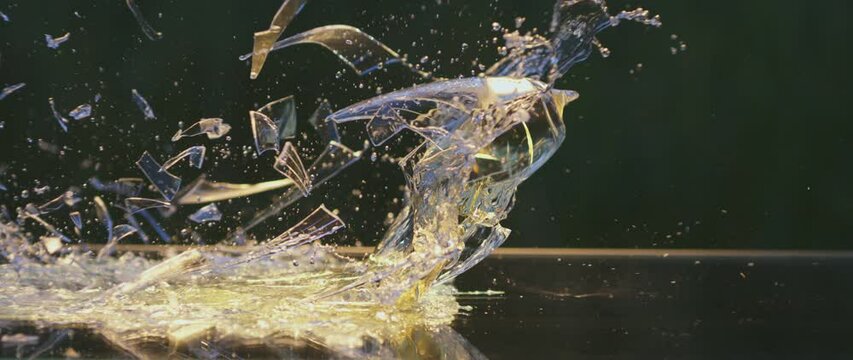 Slow-motion of white flute wine glass faling down and breaking