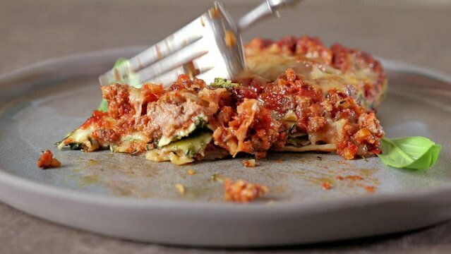 Close-up of traditional Italian lasagna with bolognese. Fork-cutting delicious lasagna, close-up.