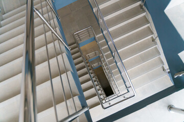 Stairwell in a modern building. Staircases as an emergency evacuation exit from the building in case of fire or emergency. Clean stairs and railings in the business center.