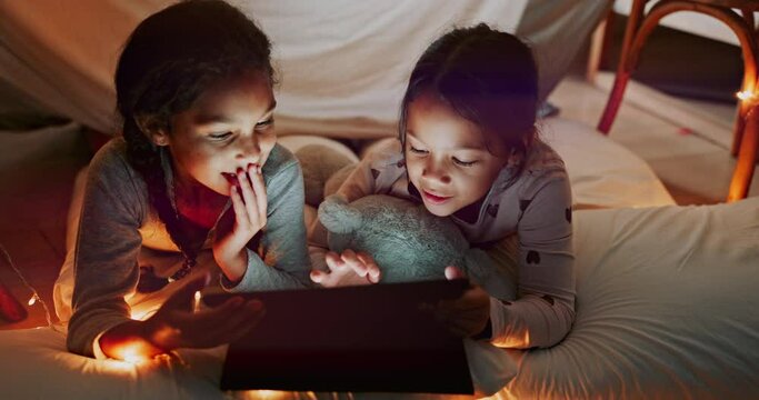 Family, tablet and girl sisters in a bedroom tent together, reading a story online or browsing social media. Children, technology and funny with friends laughing at a meme or joke on the internet