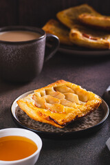 Upside down puff pastry apple tart on a breakfast plate vertical view