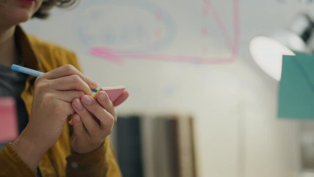 Ideas, CEO responsibly sticks a note sticker on a glass board indoors. General perspective experienced professional brainstorming with modern technology, flexible method