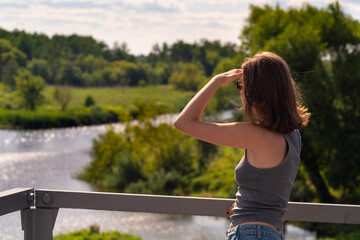 Young woman looking at the river from the bridge