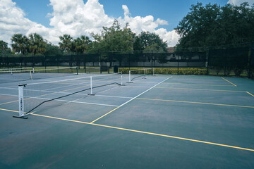 Portable pickleball nets on a tennis court in Florida