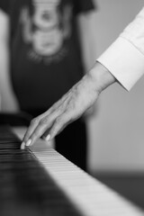 Piano keyboard background background with hand selective focus, study music. black and white photo