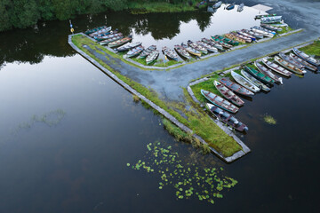 drone shot of small fishing and rowing boats on lough sheelin harbour, ireland