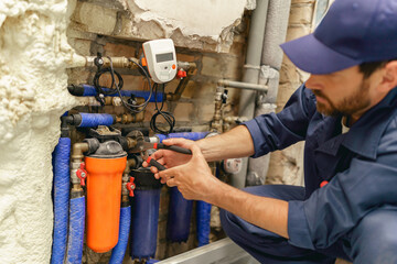 Professional plumber repairing water supply system at home uses an adjustable wrench