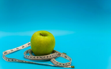 green ripe juicy apple and white measuring tape