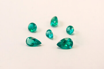 Set of cut and polished green emeralds from Colombia on white background