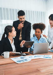 Multiracial analyst team use BI dashboard data to analyze financial report on meeting table. Group...