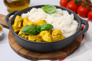 Delicious rice and chicken with curry sauce on white table, closeup