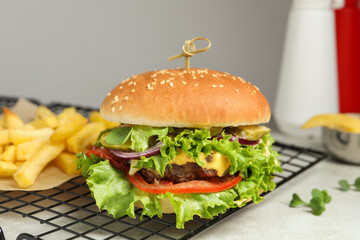 Delicious burger with beef patty and lettuce on white table, closeup