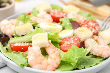 Delicious Caesar salad with shrimps on table, closeup