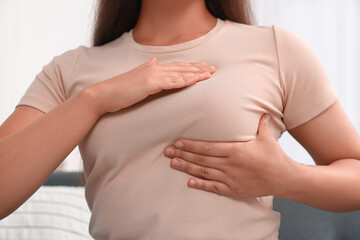 Woman doing breast self-examination at home, closeup