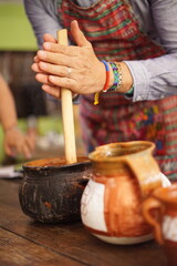 Tourist making hot chocolate with a traditional molinillo wooden whisk in Guatemala