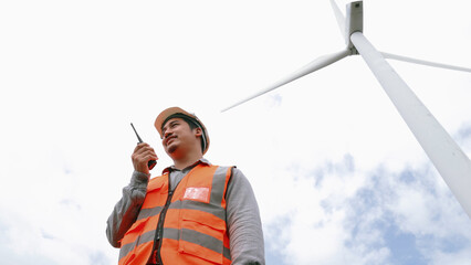 Engineer working on a wind turbine with the sky background. Progressive ideal for the future...