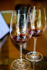 Tasting of red dry wine in Chateauneuf-du-Pape wine making village in France with green vineyards on large pebbles galets and sandstone clay soil