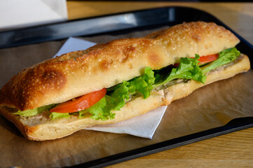 Fresh made organic sandwich with baguette buns, tuna and salad on display in bakery in France