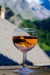 Drinking of dry dry rose wine from Savoy region with view on Hautes Alpes mountains with snow on tops in summer