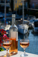Pouring in glasses of cold rose Cote de Provence wine in yacht harbour of Port Grimaud, summer vacation on French Riviera Provence, France