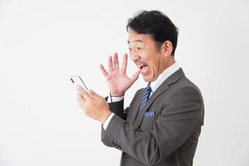 スマートフォンを持って驚くミドルエイジのビジネスマン　白背景