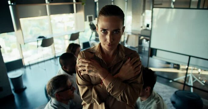 A blond woman in brown business clothes falls into the hands of her colleagues. Confidence Therapy in the Office