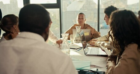 Offline conference of office workers, a guy and a girl in business clothes communicate at a table in the office. Near them sit their colleagues