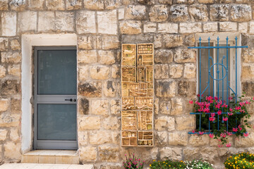 Fototapeta na wymiar Stone wall decorated with product of local artists in the famous artists village Ein Hod near Haifa in northern Israel