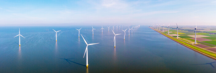 Obraz premium Windmill Park with clouds and a blue sky, windmill park in the ocean aerial view of wind mill turbines at sea