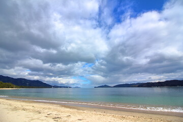 Fototapeta na wymiar 広がる分厚い雲と青い海と白い浜