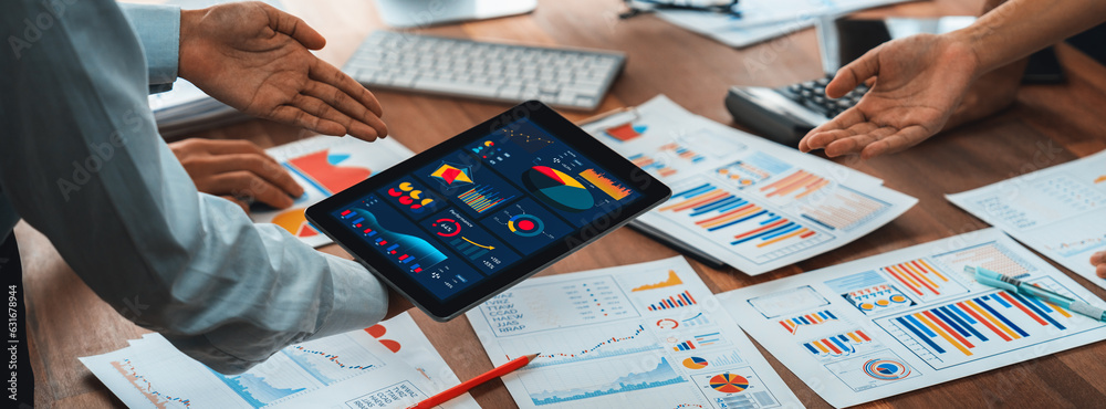 Leinwandbilder Analyst team utilizing BI Fintech to analyze financial report with tablet over paper on table and analyzing BI power dashboard display on tablet screen for business insight. Panorama shot. Scrutinize