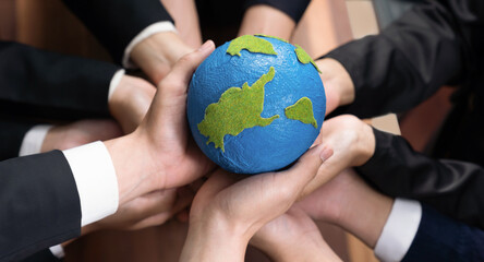 Top view business people holding Earth together in synergy as team building to utilize eco...