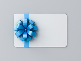 Blank white gift card with blue ribbon bow or gift voucher isolated on gray background with shadow...