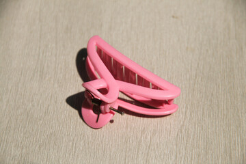 Pink hair clip made of plastic with reflections and shadows for those with long hair and looks...