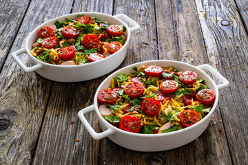 Bread casserole with mozzarella cheese, tomatoes and scrambled eggs on wooden table
