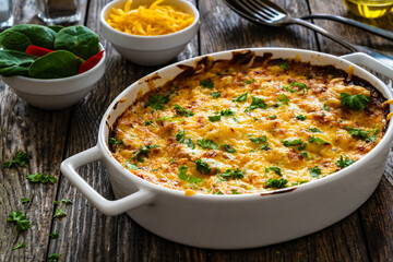 Potato casserole with mozzarella cheese and bechamel sauce on wooden table
