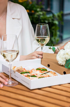 Romantic date outside on the terrace. Two glasses with wine and italian pizza. Close-up photo