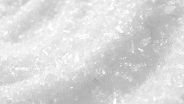 Monosodium glutamate (MSG) is a flavor enhancer commonly used in food. In a macro video, explore its fine, crystal-like structure and watch as it dissolves into a savory delight. Food background.
