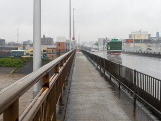 大雨の大和川に架かる橋の風景