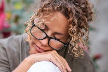 Portrait of attractive middle age woman with serene expression on face and eyes closed wearing...